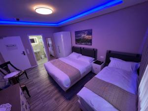 two beds in a room with purple lights at 3A Hotel 