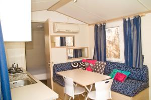 uma sala de estar com uma mesa e um sofá em Camping & Village Polvese em Sant Arcangelo