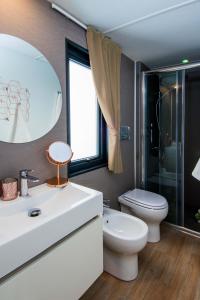 a bathroom with a sink and a toilet and a mirror at Piani di Clodia Holidaypark in Lazise