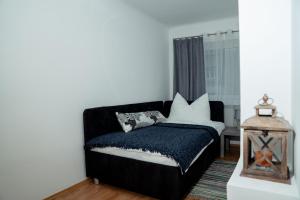 Schlafzimmer mit einem schwarzen Bett und weißen Kissen in der Unterkunft Bessemer in Wien