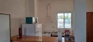 uma cozinha com um frigorífico branco e uma janela em Sol y Malbec Departamentos em Guaymallén