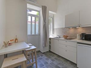 een keuken met witte kasten en een raam bij Are You Ready for a Truly Athenian Experience? in Athene