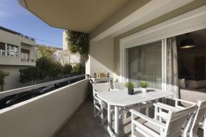 patio z białym stołem i krzesłami na balkonie w obiekcie 3BR Prime APT a breath away from the Acropolis! w Atenach