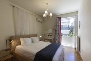 sypialnia z łóżkiem i dużym oknem w obiekcie 3BR Prime APT a breath away from the Acropolis! w Atenach