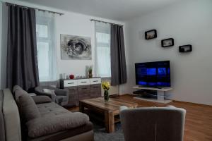 ein Wohnzimmer mit einem Sofa und einem TV in der Unterkunft Bessemer in Wien