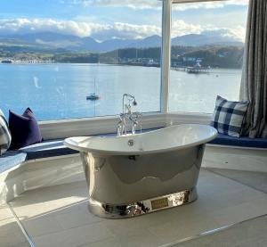 a bath tub in a room with a large window at Anglesey Beach House in Menai Bridge