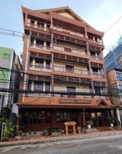 um grande edifício de madeira com varandas numa rua da cidade em Khampiane1 Hotel em Ban Nongdouang