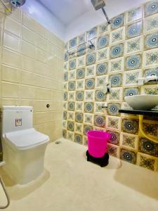 a bathroom with a toilet and a sink and a bucket at Haveli BALAVH with lake facing balcony in Udaipur