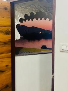 a painting of a sunset on a shelf at Haveli BALAVH with lake facing balcony in Udaipur