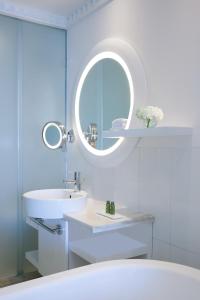 Baño blanco con lavabo y espejo en Sofitel Dubai Jumeirah Beach, en Dubái