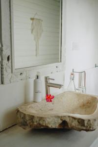 baño con lavabo de mármol y dispensador de jabón en Shrining Cottages Lembongan en Nusa Lembongan