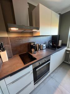 a kitchen with white cabinets and a stove top oven at FineApartment Borgstedt in Borgstedt