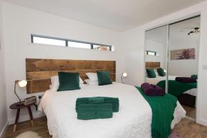 ein Schlafzimmer mit einem großen weißen Bett mit grünen Kissen in der Unterkunft The Garage in Welshpool