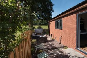 a backyard with a brick house and a fence at The Garage in Welshpool