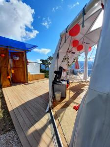 a white tent with a blue canopy and a wooden deck at Glamping Campestre Uriyahu in Macanal