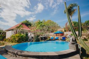 a swimming pool with a statue next to a house at Shrining Cottages Lembongan in Nusa Lembongan