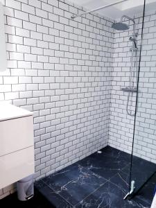 a white tiled shower with a black floor in a bathroom at La Pléiade Dorée - Extra Centre - Wifi HD - Terrasse & Jardin in Amiens +3 photos