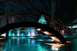 un puente sobre una piscina de agua por la noche en Holiday Club Saimaa Superior Apartments, en Imatra