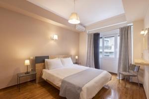 a bedroom with a large bed and a window at Prime Location 2 BR APT next to the Acropolis in Athens