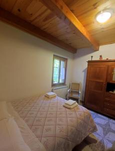 una camera con un grande letto e un soffitto in legno di Agriturismo il fosso a Cutigliano
