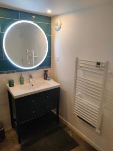 een badkamer met een wastafel en een spiegel bij L'Atelier in Saint-Laurent-Blangy