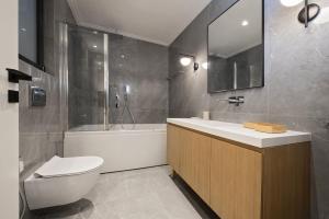 La salle de bains est pourvue de toilettes, d'un lavabo et d'une baignoire. dans l'établissement Chic central Athens apartment at Mavilli Sq., à Athènes