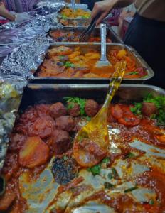 a buffet line of trays of food with utensils at White Desert Camp in Wadi Rum