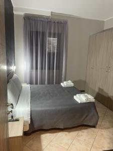Zumpano的住宿－B&B Menna Vence，一间卧室设有一张大床和一个窗户。