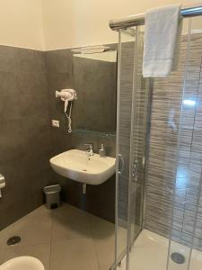 een badkamer met een wastafel en een glazen douche bij B&B Menna Vence in Zumpano