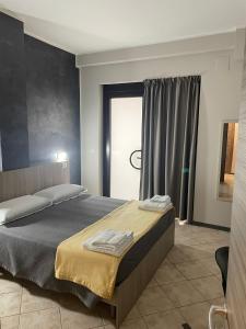 een slaapkamer met een groot bed en een raam bij B&B Menna Vence in Zumpano