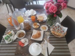 a table with breakfast foods and a vase of flowers at B&B Menna Vence in Zumpano +16 photos