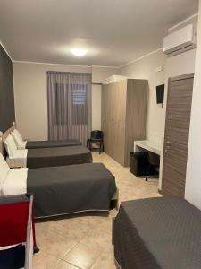 een hotelkamer met 2 bedden en een bureau bij B&B Menna Vence in Zumpano