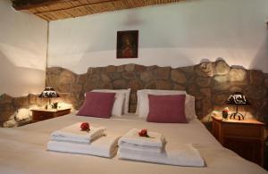 a bedroom with a bed with towels and two lamps at Posada Con Los Ángeles in Tilcara