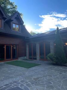 a house with a stone patio in front of it at CHALET RaJ in Gelnica