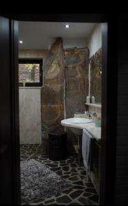 a stone bathroom with a sink and a shower at CHALET RaJ in Gelnica