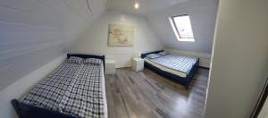 a attic bedroom with two beds and a window at Domki Morska in Rewa