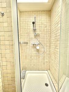 een badkamer met een douche en een bad met een douche bij Le Castel 1 C.L.S Deauville in Deauville