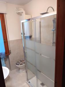 a bathroom with a glass shower and a toilet at Caletta Beach in Castiglioncello