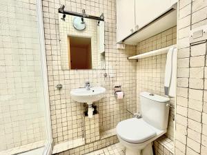 łazienka z toaletą i umywalką w obiekcie Le Castel 1 C.L.S Deauville w mieście Deauville