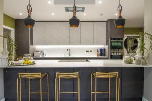 a kitchen with a counter with gold bar stools at Festival Villa and City Villa in Edinburgh