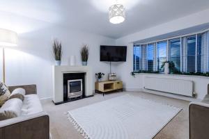 Luxurious Cosy 4BR Home Cheshire في Saughall: غرفة معيشة مع أريكة ومدفأة