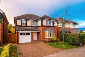 a brick house with a white garage at Luxurious Cosy 4BR Home Cheshire in Saughall