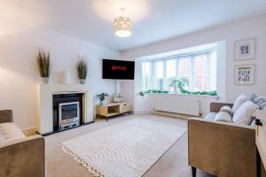 ein Wohnzimmer mit einem Kamin und einem TV in der Unterkunft Luxurious Cosy 4BR Home Cheshire in Saughall