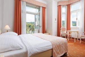 a bedroom with a bed and a large window at OREA Spa Hotel Palace Zvon Mariánské Lázně in Mariánské Lázně +38 photos