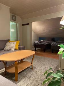 a living room with a couch and a table at Koskentien kotimajoitus & Luxury Glamping in Jämsä