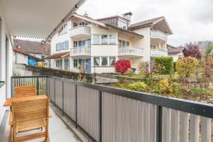 a balcony with a white fence and a wooden chair at Apartment zum Genießen in Garmisch-Partenkirchen
