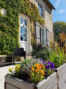 a garden in front of a house with flowers at Val de Gée in Maigné