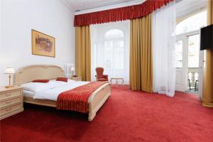 マリアーンスケー・ラーズニェにあるOREA Spa Hotel Palace Zvon Mariánské Lázněの赤いカーペットフロアのベッドルーム1室(大型ベッド1台付)