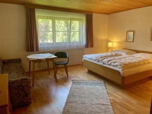 een slaapkamer met een bed, een tafel en een stoel bij Apartment Ilishof in Schruns