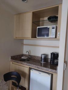 a kitchen with a counter top with a microwave at Lets Idea Hotel Flat Particular in Brasilia